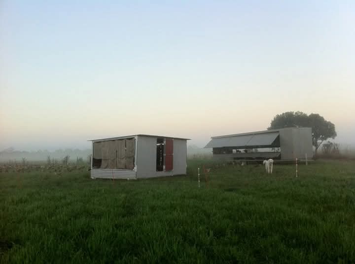 The brooder next to the first Chicken Caravan 450 Chicken Caravan brooder shed and first chicken caravan