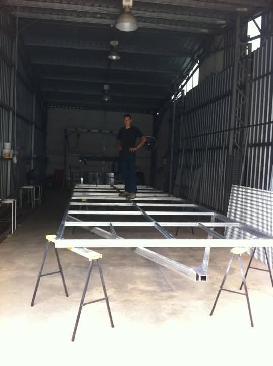 Evan in their very first workshop building one of the first Chicken Caravan 450s that would go out to a customer Evan on one of the first frame for a Chicken Caravan being sold